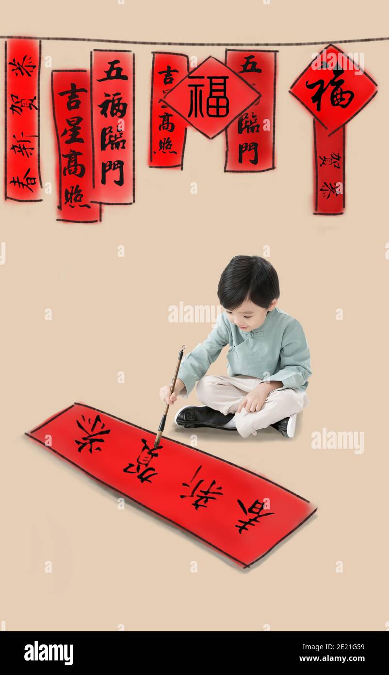 The little boy sat cross-legged sitting write Spring Festival couplets ...