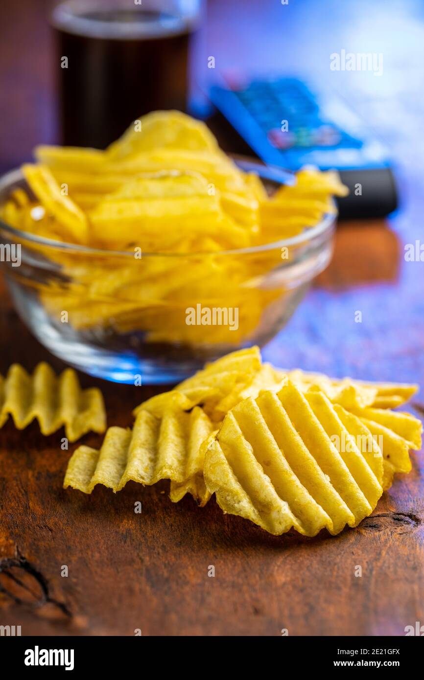 Crispy potato chips on wooden table Stock Photo