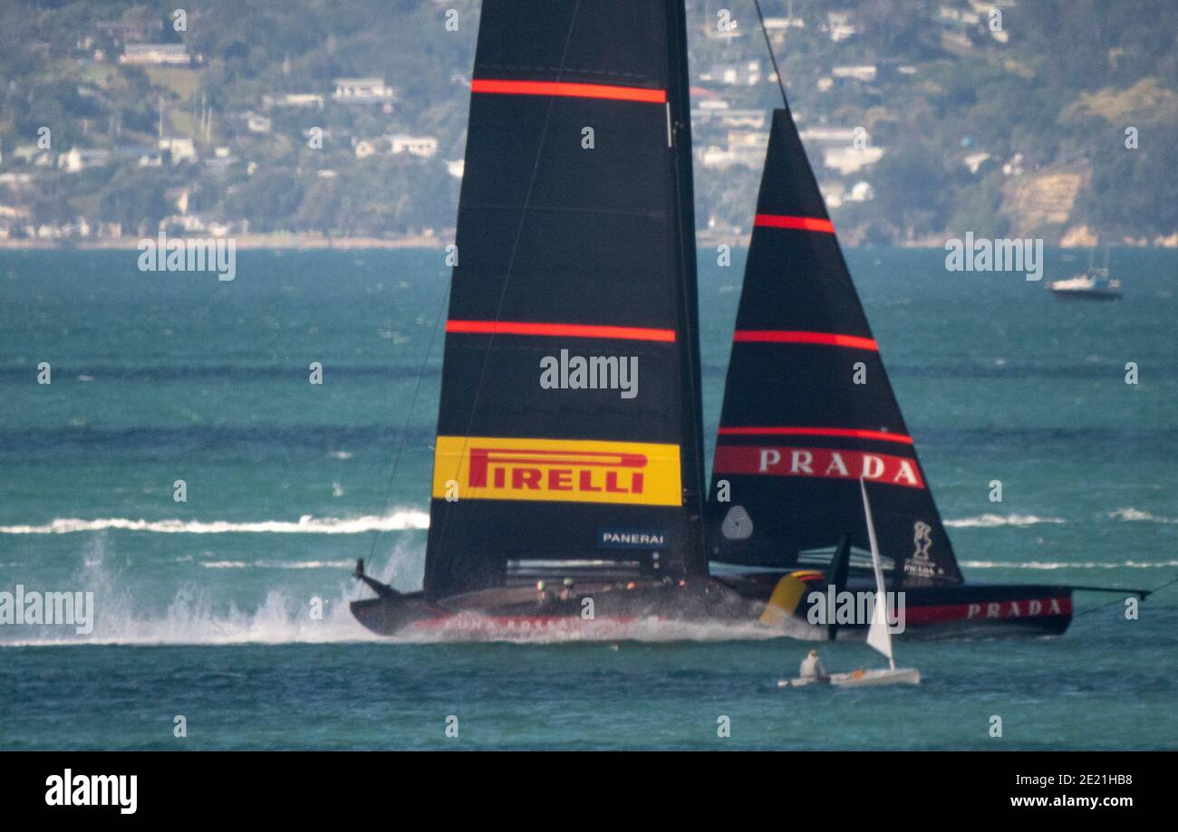 Auckland, New Zealand, 11 January, 2021 -  Italian team Luna Rossa Prada Pirelli, skippered by Max Sirena,  dwarf a small dingy sailor spectator as they compete in a practice race on the Waitemata Harbour ahead of the The Prada Cup competition starting on January 5, 2021 Credit: Rob Taggart/Alamy Live News Stock Photo