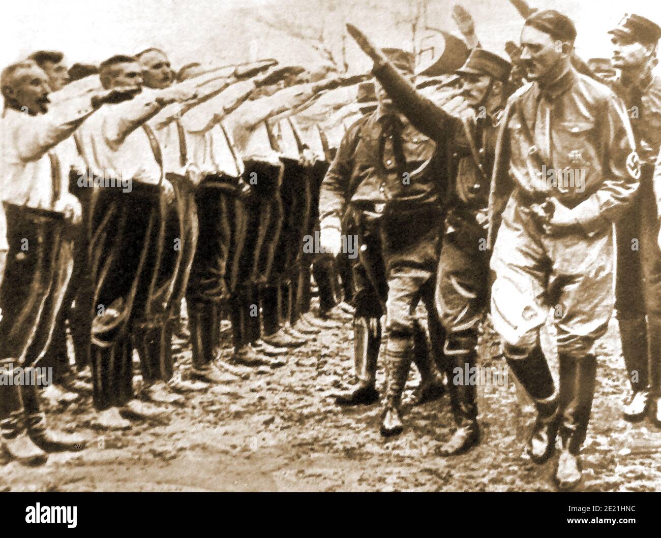 Adolph Hitler inspecting his new 'Brown Shirts' in 1930 -(from a press picture of the time). They were also known as Braunhemden, Sturmabteilung, the SA, and Storm Detachment.  Their primary purpose was to  provide protection for Nazi rallies and other assemblies; and to disrupt  the meetings and gatherings of  any  opposing parties.The SA developed pseudo-military titles and ranks  for its members,   that were later adopted by several other Nazi Party groups. Their name comes from their standard mode of dress.(Rudolph Hess can be seem immediately to the right behind Hitler). Stock Photo