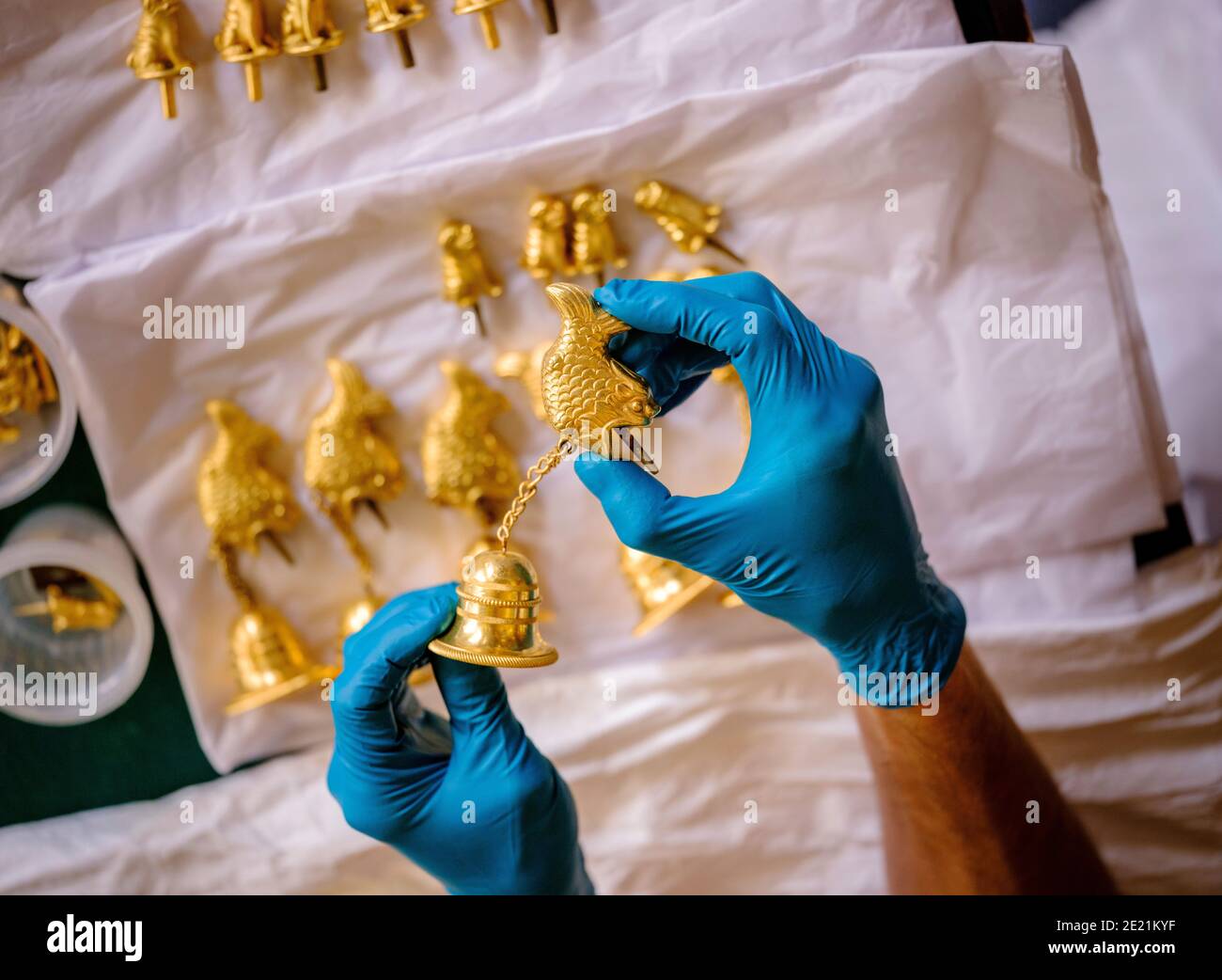 The Royal Pavilion Brighton: The music room during the exhibition of the Royal Colection a Prince's Treasure on loan 2020 and 2021. A conservator  with gilded bells preparing to be attached to the giant pagodas that form a key part of the exhibition. Stock Photo