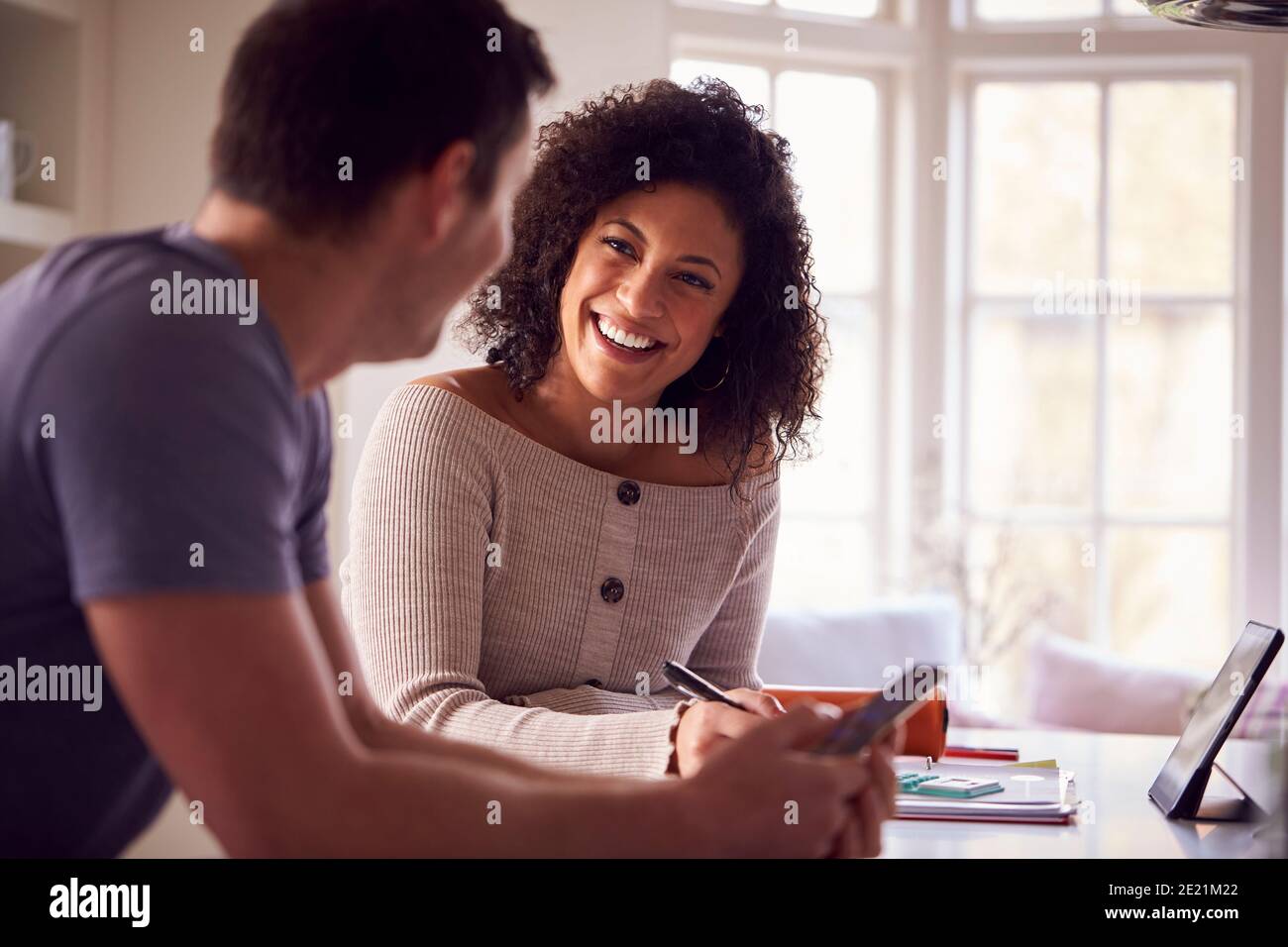 Couple With Digital Tablet Working From Home On Kitchen Counter Stock Photo
