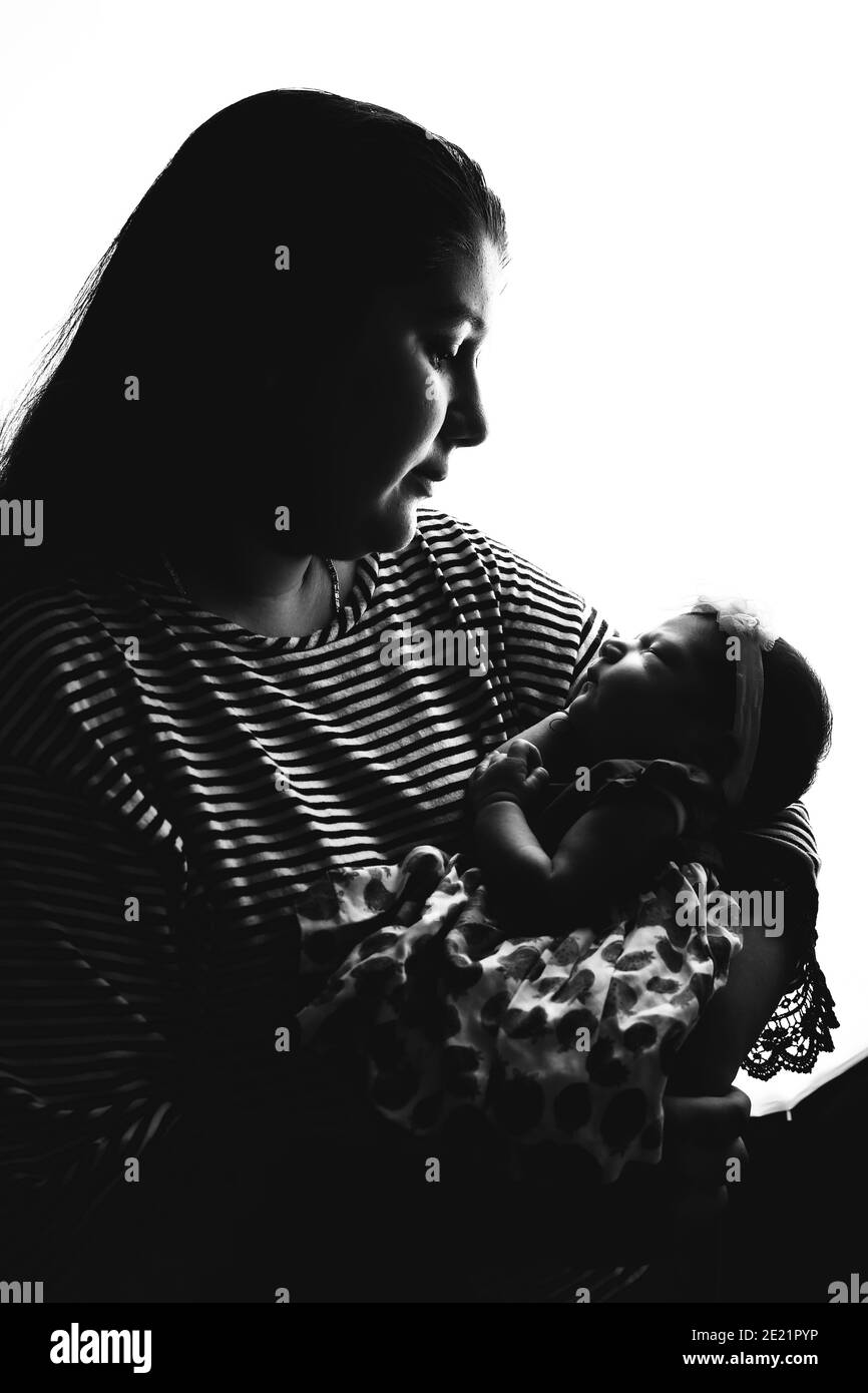 A lovely black and white image of a young fresh mother holding her newborn baby girl with copy space. Stock Photo
