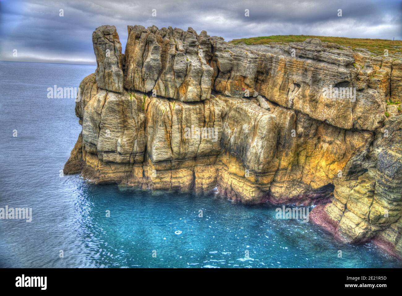Fotografia de un acantilado rocoso en hdr de colores brillantes ubicado en el mar Cantabrico, cerca de Santander Stock Photo