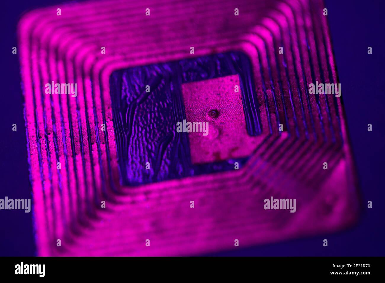 Close up of RFID tag under ultraviolet light. Stock Photo