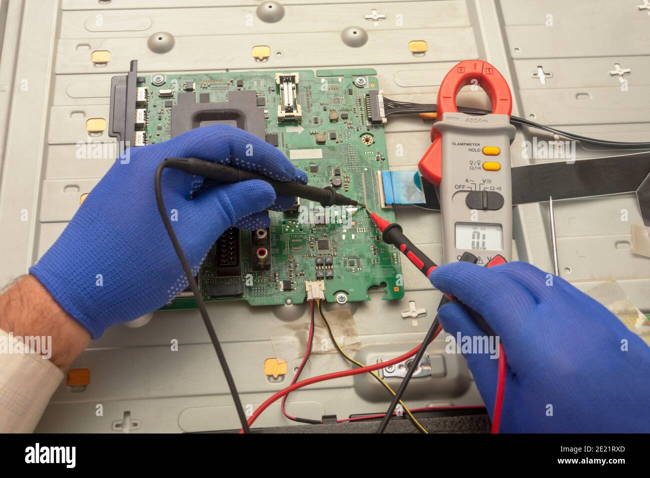 Volgograd, Russia - September, 2020: Diagnostics of printed circuit board TV. Hands hold the resistance test lead. Selective focus. Stock Photo