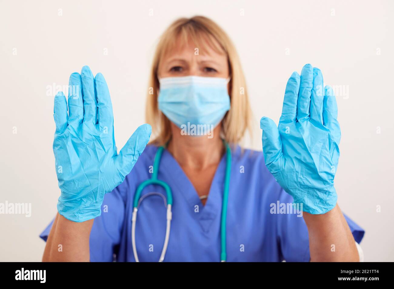 Studio Portrait Of Female Nurse Wearing Scrubs And PPE Face Mask And ...