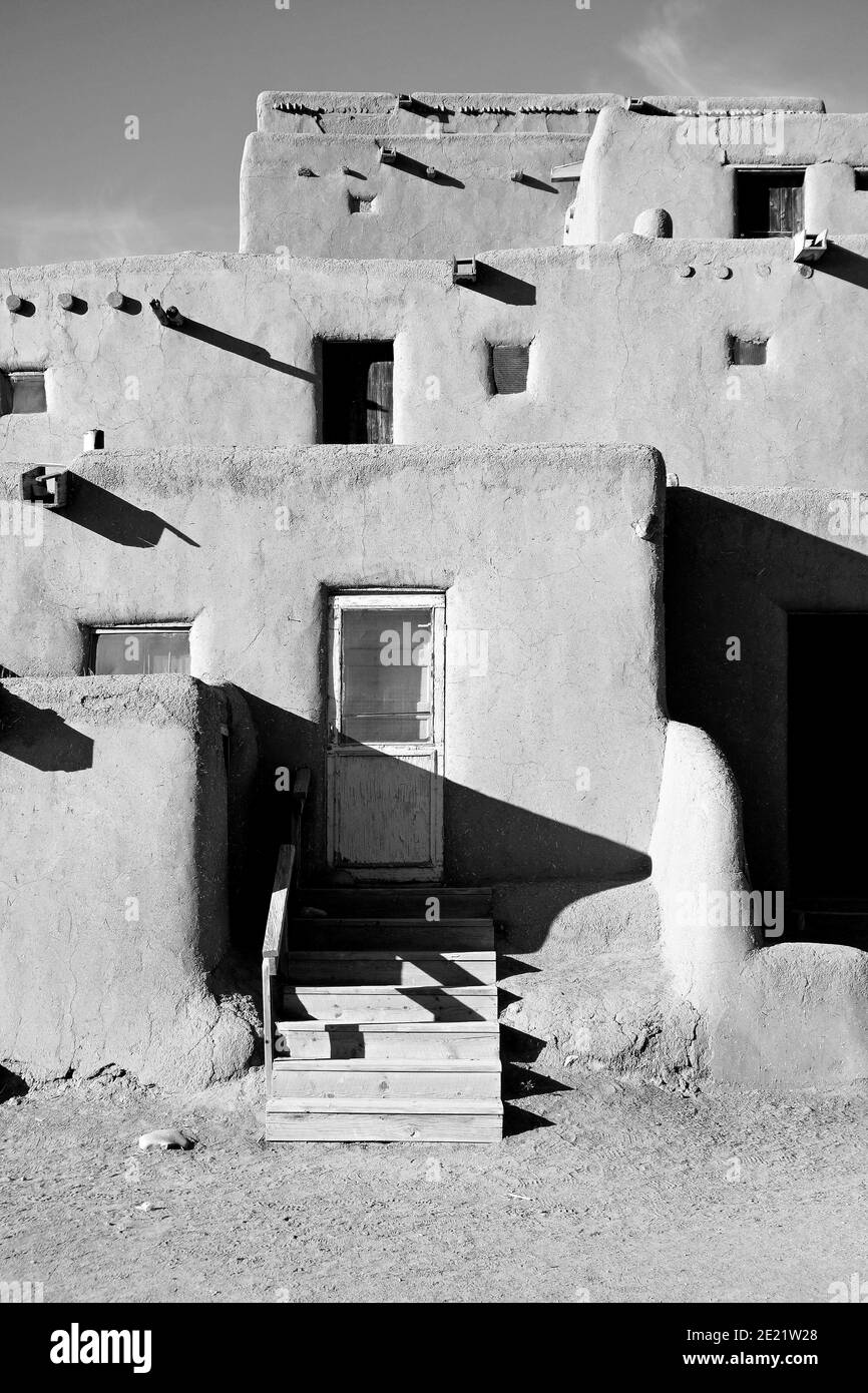 Grayscale shot of old buildings of Taos Pueblo under the sunlight in New Mexico Stock Photo