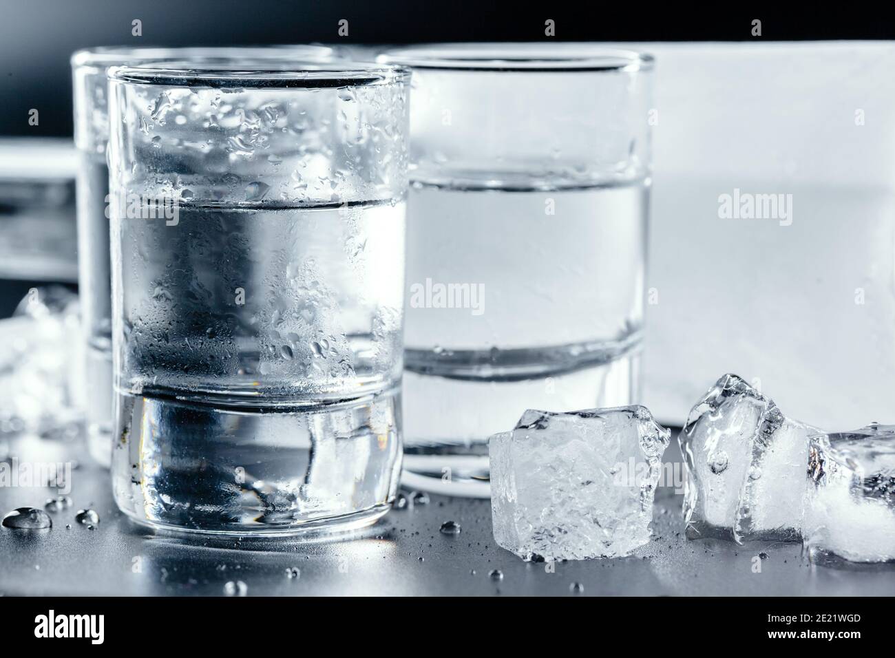 Cold vodka in shot glasses on a black background Stock Photo - Alamy