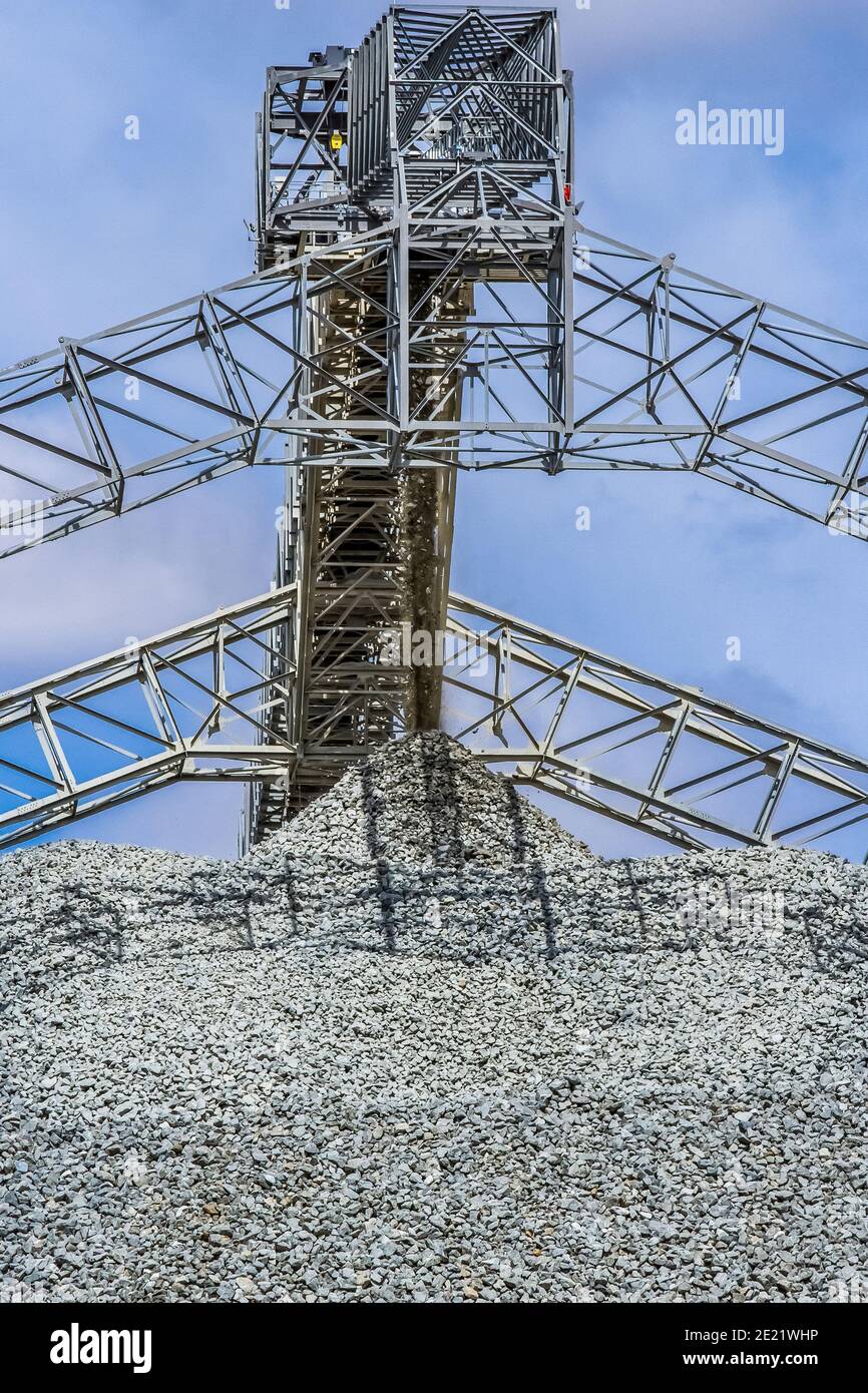 Low angle shot of a rump ejecting crushed stones in a mining site in