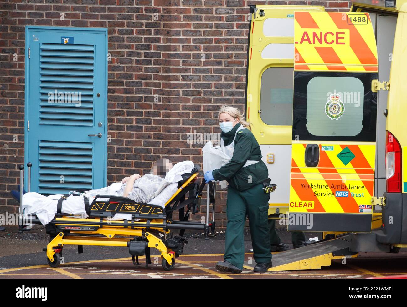 XXXX HOLD PIC XXXX Ambulance crew transport a patient from an ambulance outside Doncaster Royal Infirmary during England's third national lockdown to curb the spread of coronavirus. Under increased measures people can no longer leave their home without a reasonable excuse and schools must shut for most pupils. Stock Photo