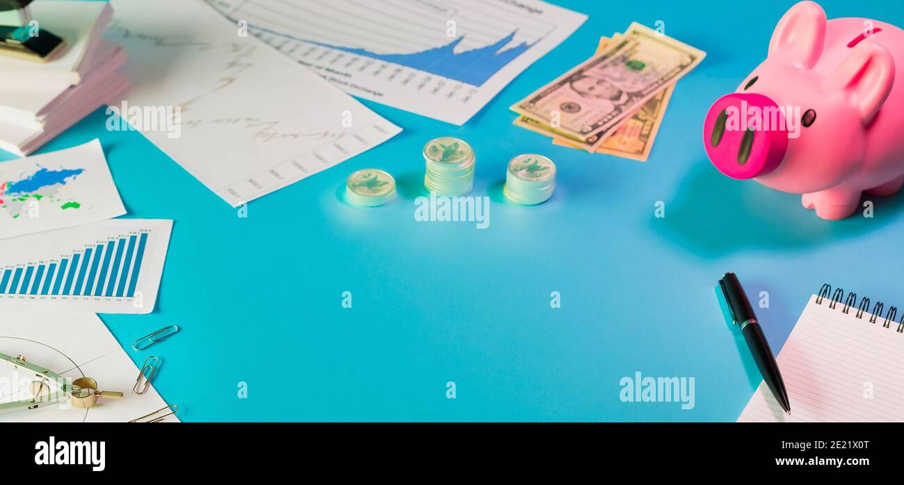 Shot of coins, cashbox, documents on a blue surface - business, investment concept Stock Photo