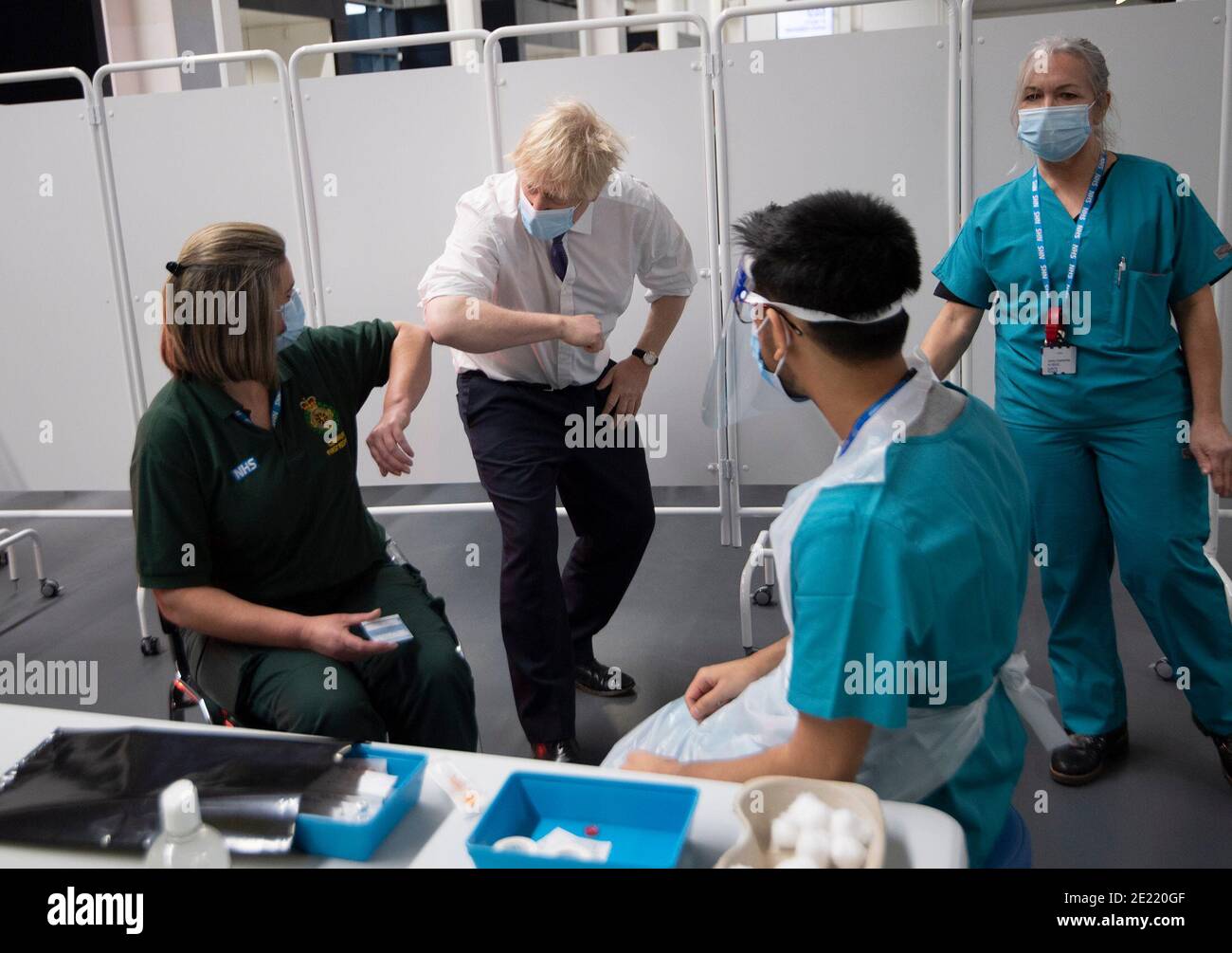 Prime Minister Boris Johnson at Ashton Gate Stadium in Bristol greets first responder Caroline Cook before she receives an injection of a Covid-19 vaccine during a visit to one of the seven mass vaccination centres now opened to the general public as the government continues to ramp up the vaccination programme against Covid-19. Stock Photo