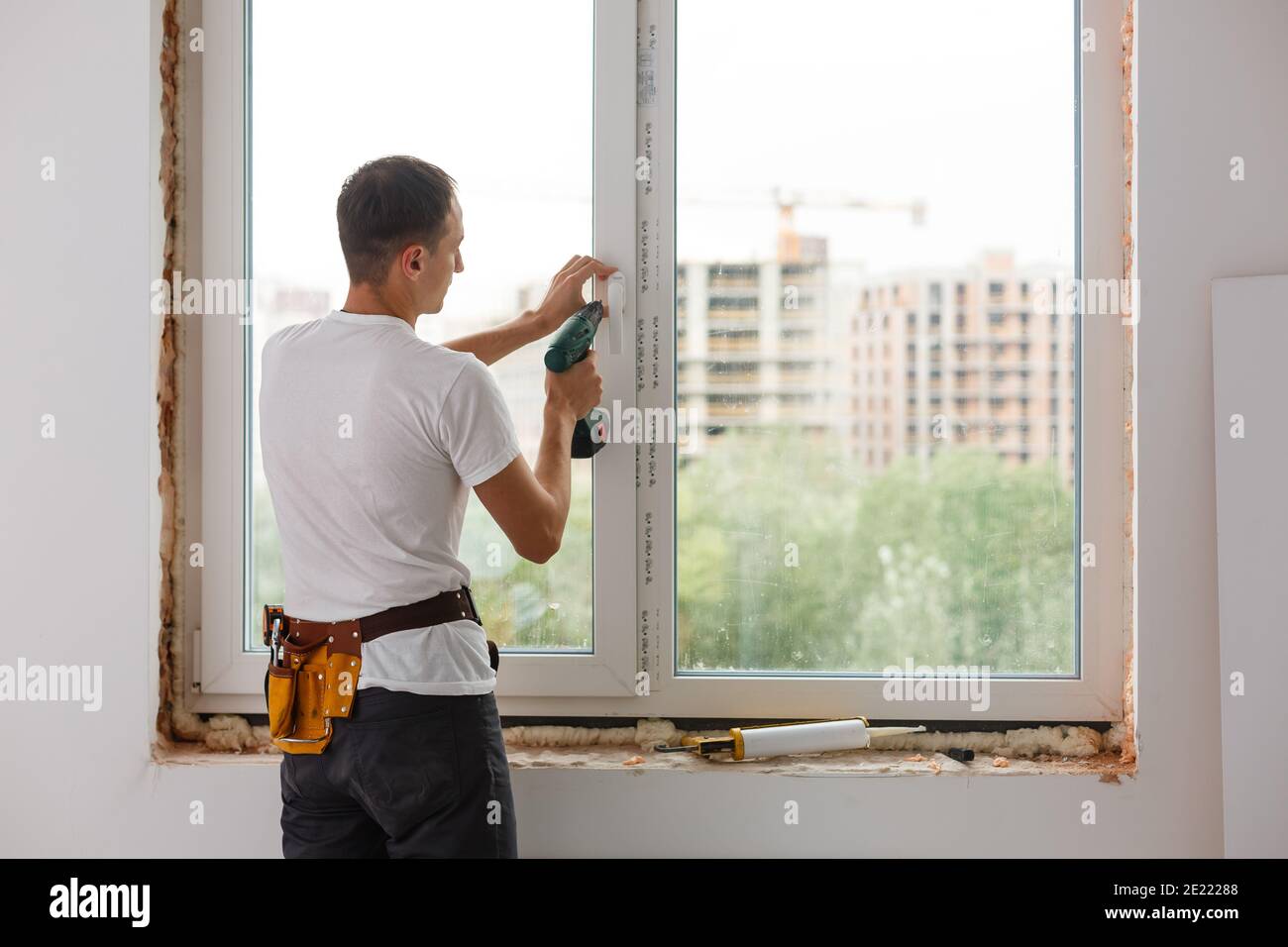 Young handyman repair window with screwdriver Stock Photo