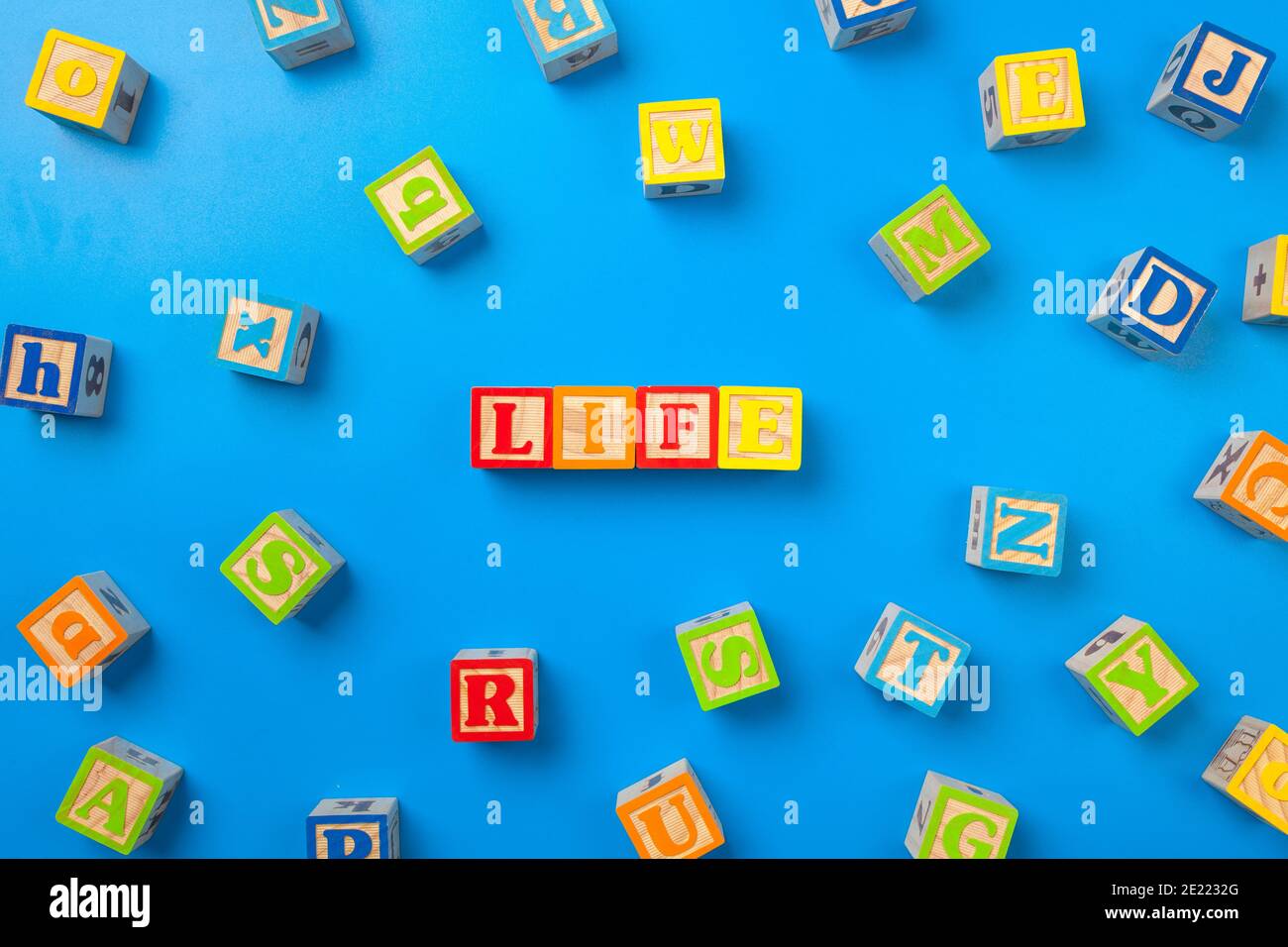 Life. Wooden colorful alphabet blocks on blue background, flat lay, top ...