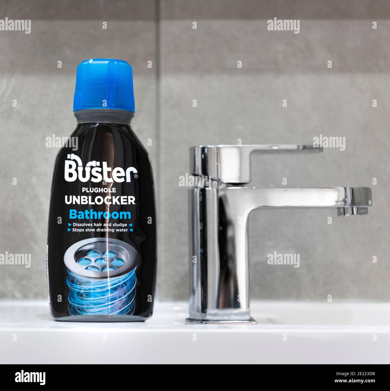 Buster plughole unblocker for bathrooms in a tiled background Stock Photo