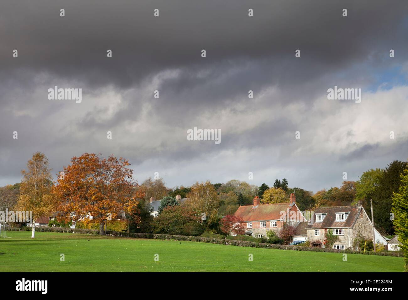 Houses at the edge of the village green and recreation ground in Dinton, Wiltshire. Stock Photo