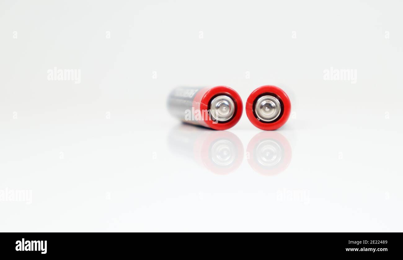 Two type AAA alkaline rechargeable batteries on white glossy background with reflection with copy space Stock Photo