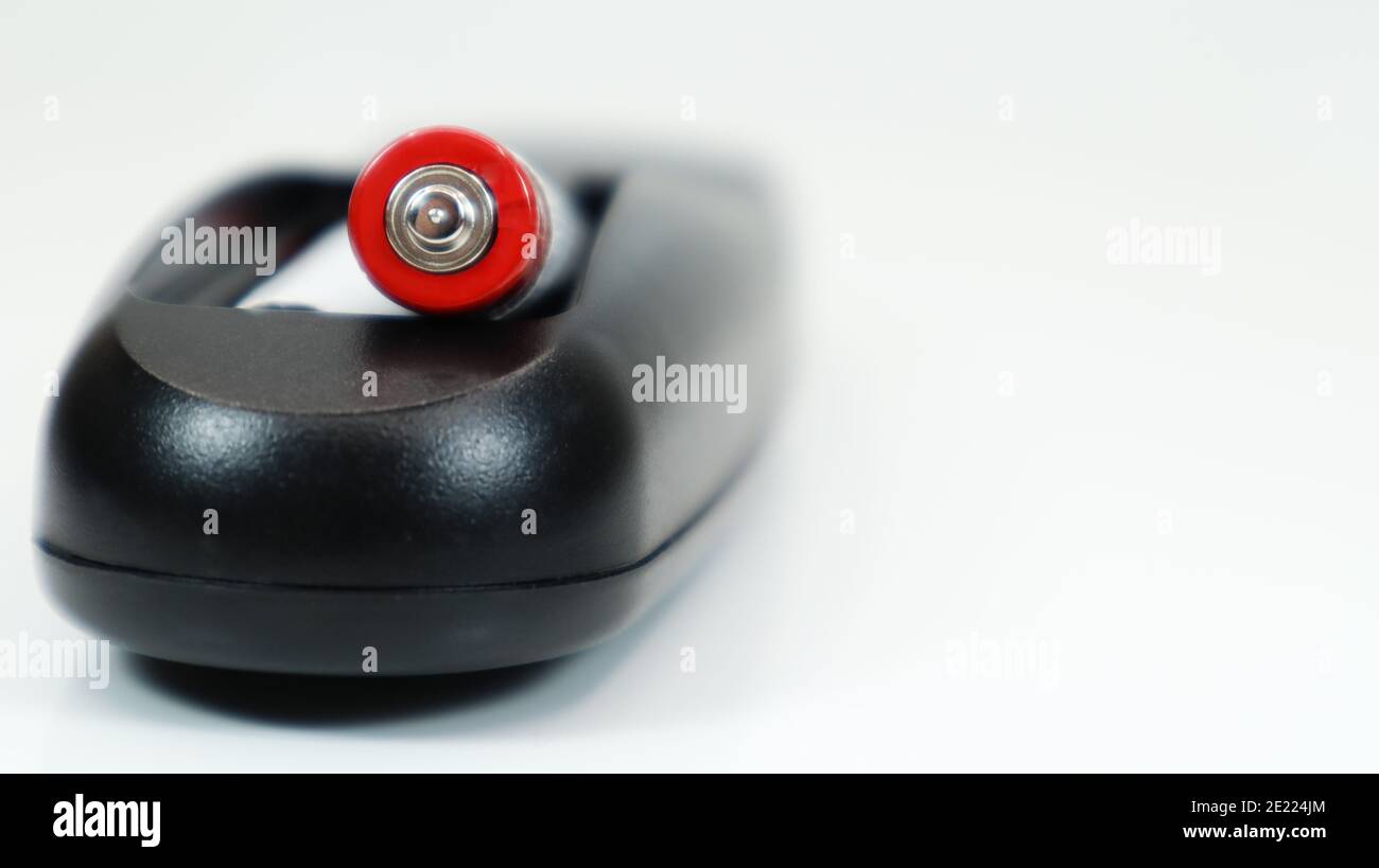 Black TV remote control with AAA alkaline batteries on a white