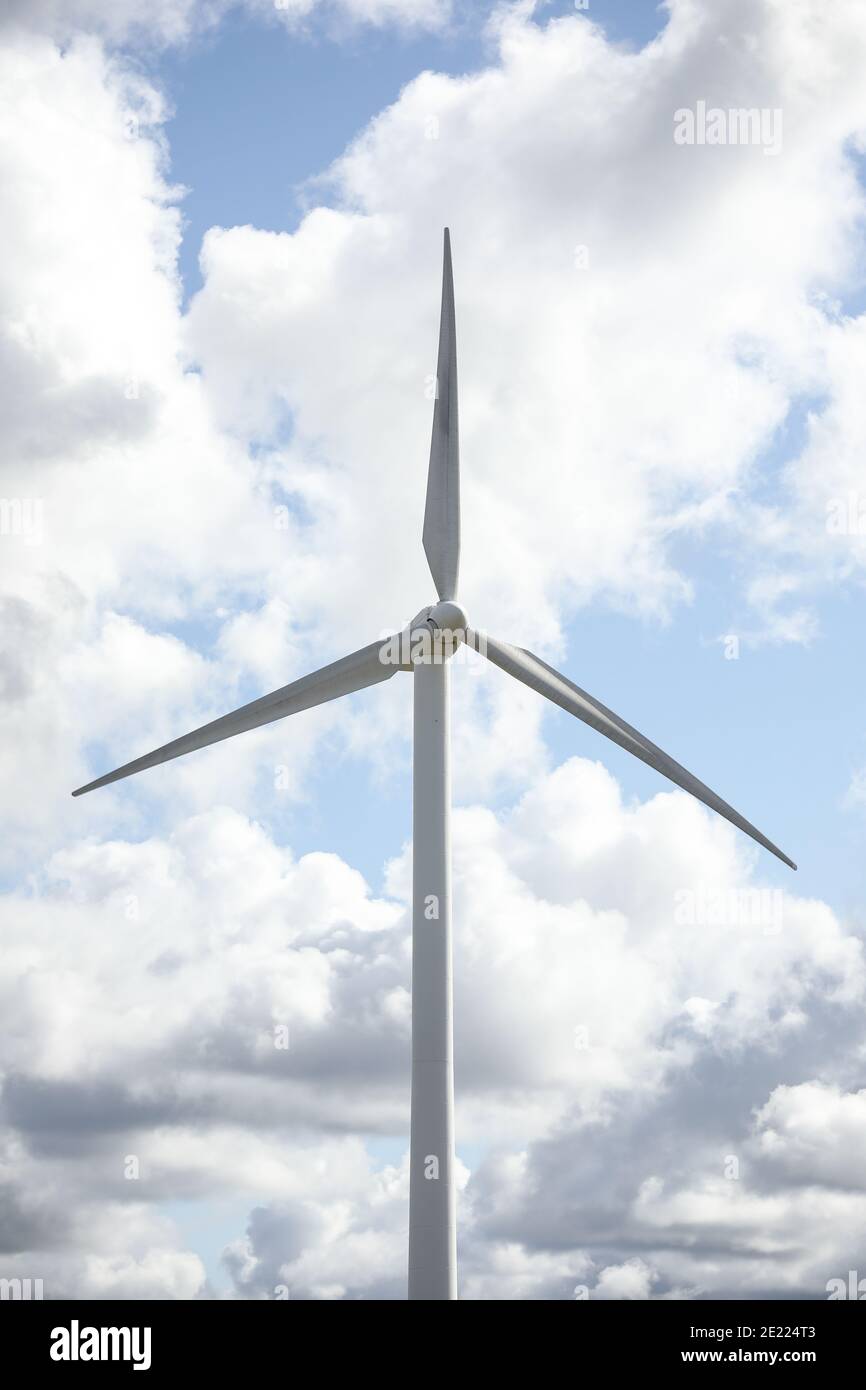 Wind turbine in a sunny day with blue sky and clouds. Wind farm eco ...
