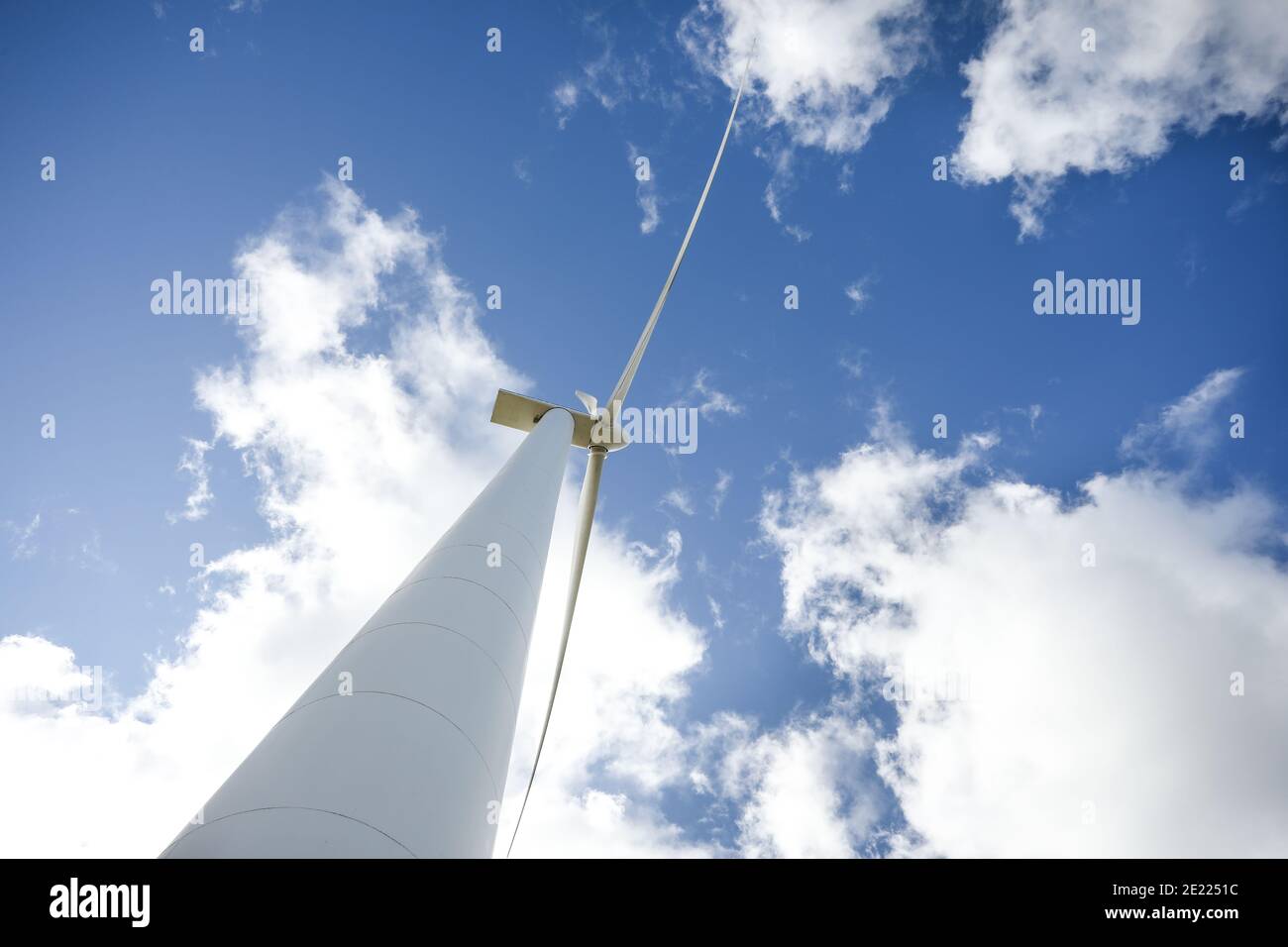 Wind turbine in a sunny day with blue sky and clouds. Wind farm eco ...