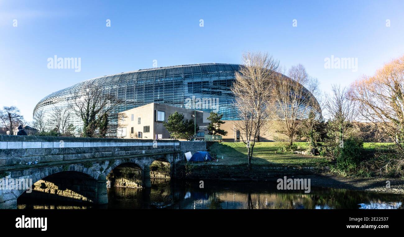 A homeless person's tent along the banks of The Dodder River, near Lansdowne Road, Dublin, Ireland, against the backdrop of the Aviva Stadium. Stock Photo