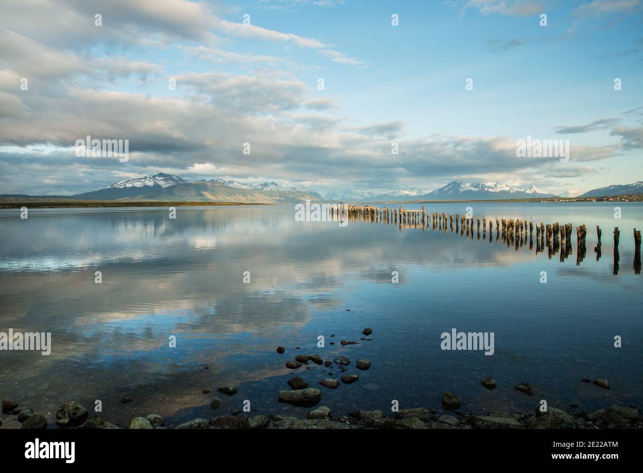 Old wooden jetty reflected in waters of the Ultima Esperanze Sound / Golfo Almirante Montt Puerto Natales, Patagonia, Chile, Andes & Torres del Paine Stock Photo