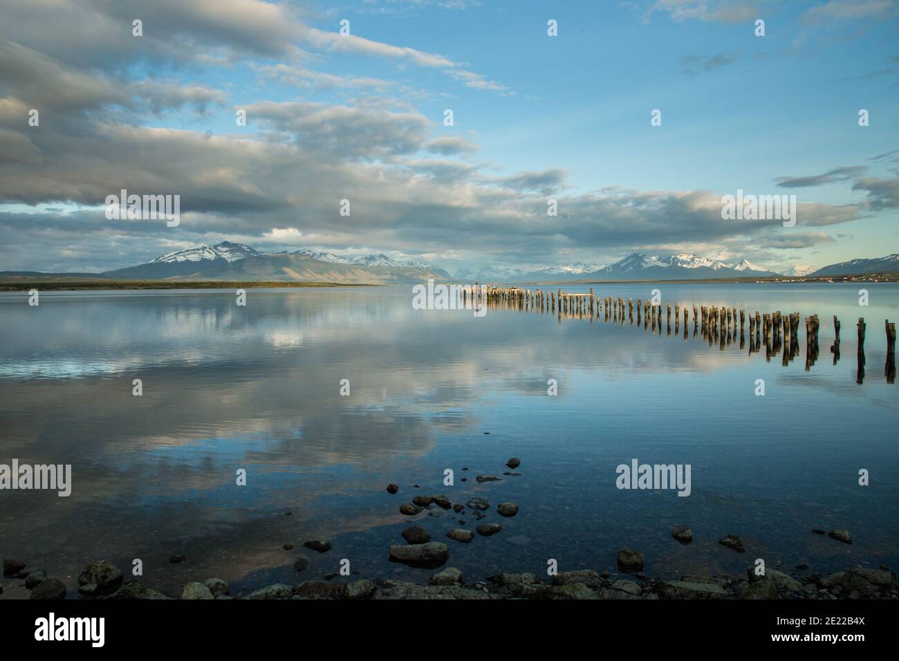 Old wooden jetty reflected in waters of the Ultima Esperanze Sound / Golfo Almirante Montt Puerto Natales, Patagonia, Chile, Andes & Torres del Paine Stock Photo