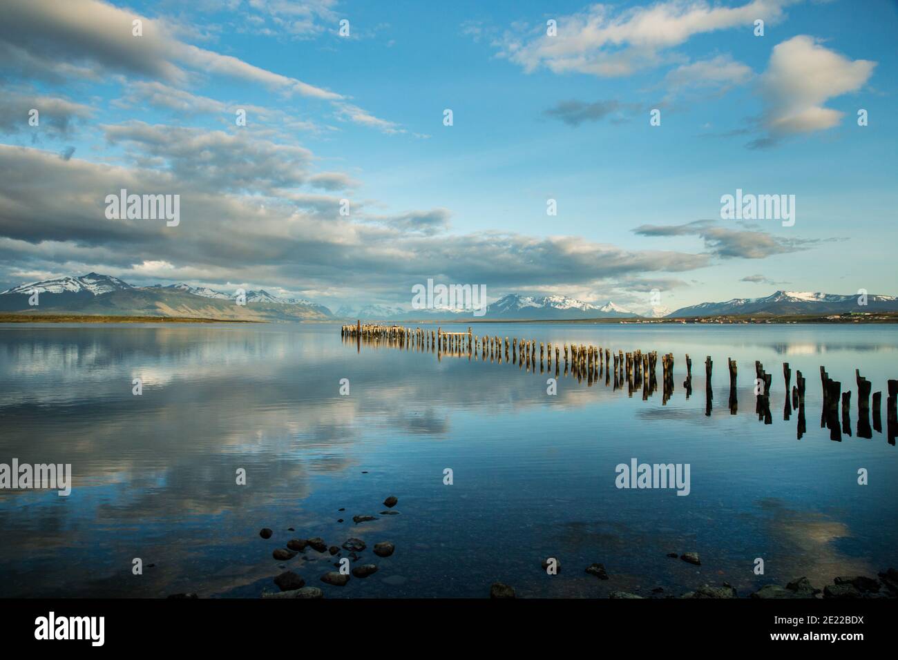 Old wooden jetty reflected in waters of the Ultima Esperanze Sound / Golfo Almirante Montt Puerto Natales, Patagonia, Chile, Andes & Torres del Paine Stock Photo
