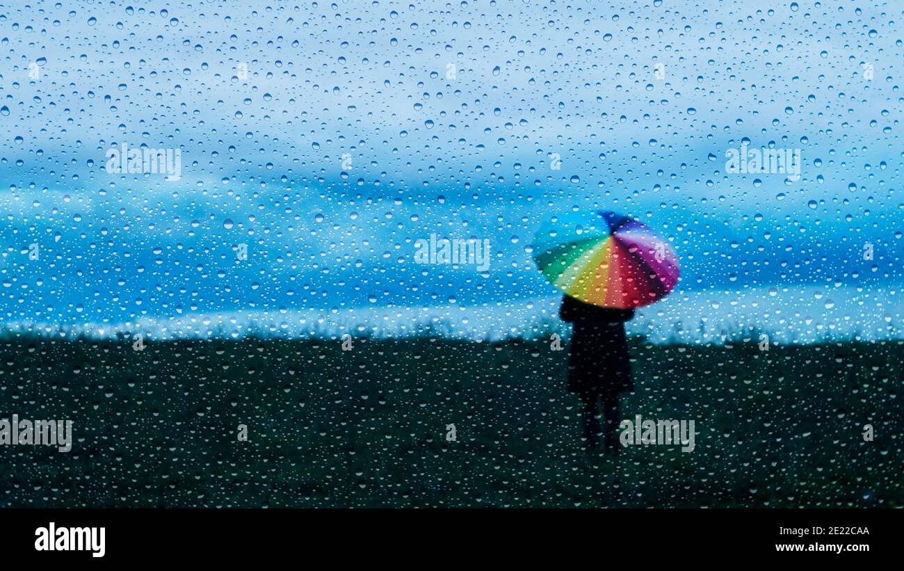 Person holding an umbrella in rain hires stock photography and images