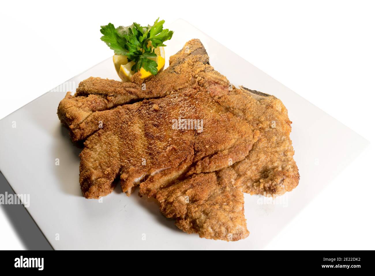 Traditional Italian veal Milanese with lemon and parsley, fried cutlet