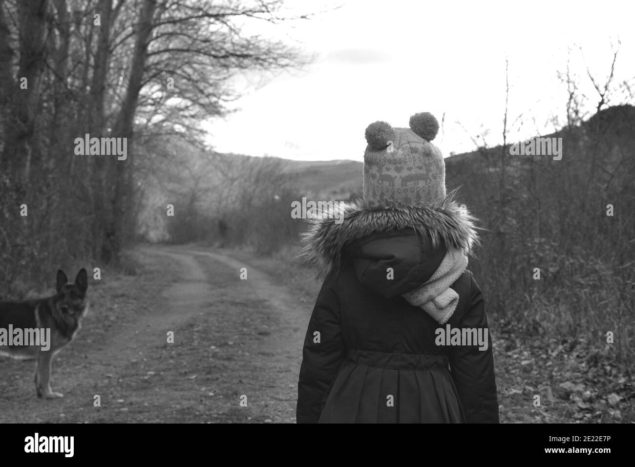 Five-year-old girl with her back turned on a rural road. Black and white photo. Munilla, La Rioja, Spain. Stock Photo