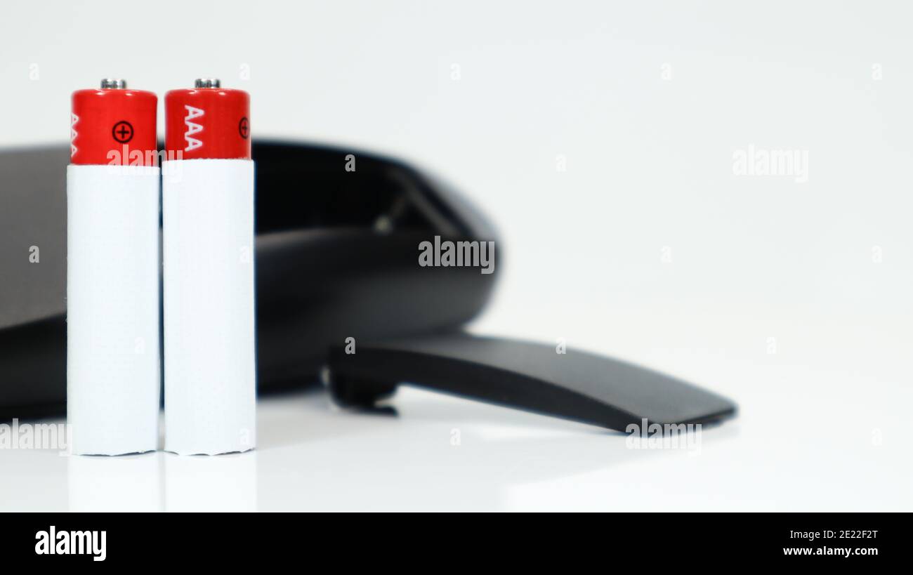 Black TV remote control with AAA alkaline batteries on a white