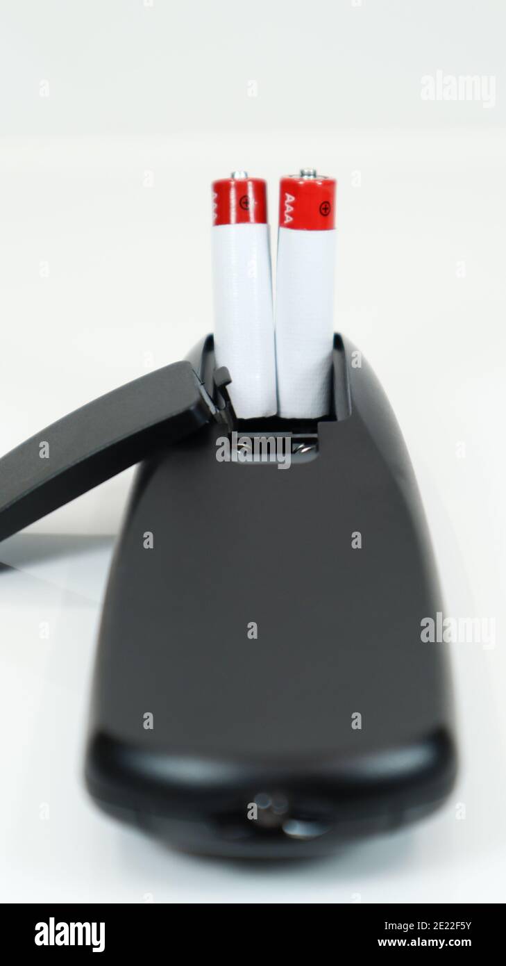 Black TV remote control with AAA alkaline batteries on a white