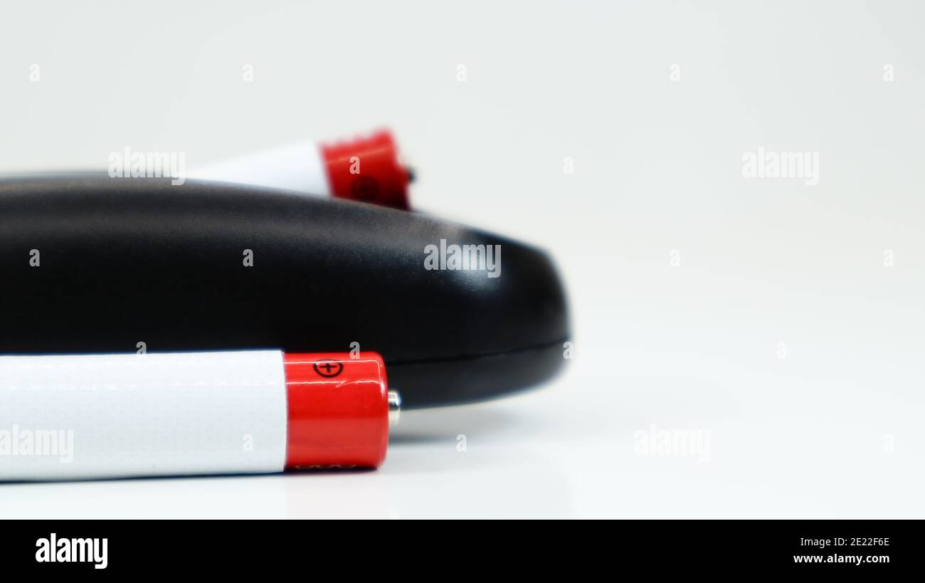 Black TV remote control with AAA alkaline batteries on a white