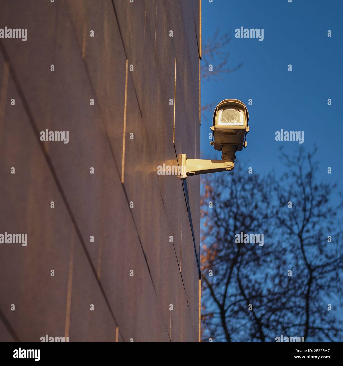 A surveillance camera takes video outside in the dark. Night security camera on the wall