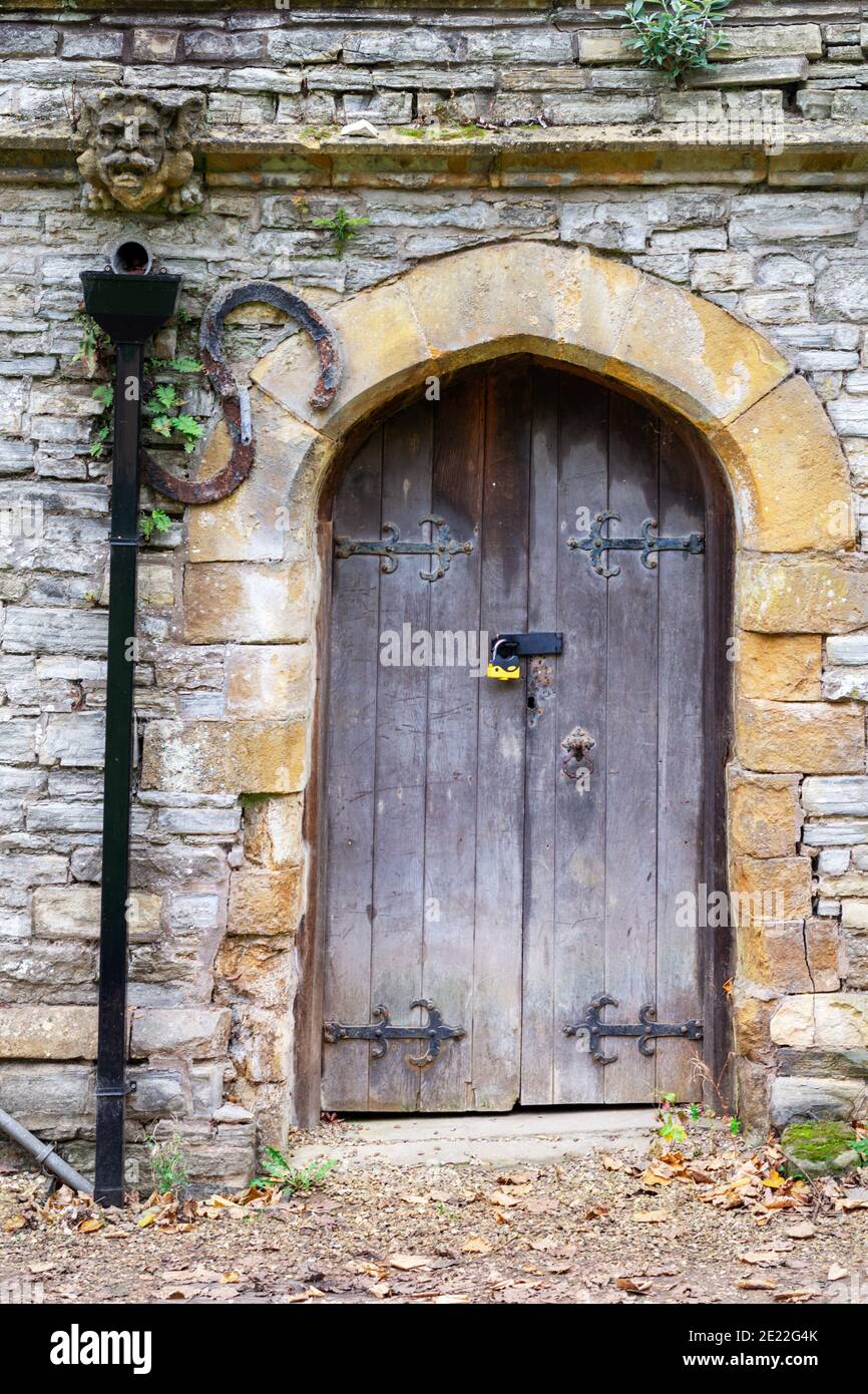 Old wooden arched doors in a stone wall Stock Photo - Alamy