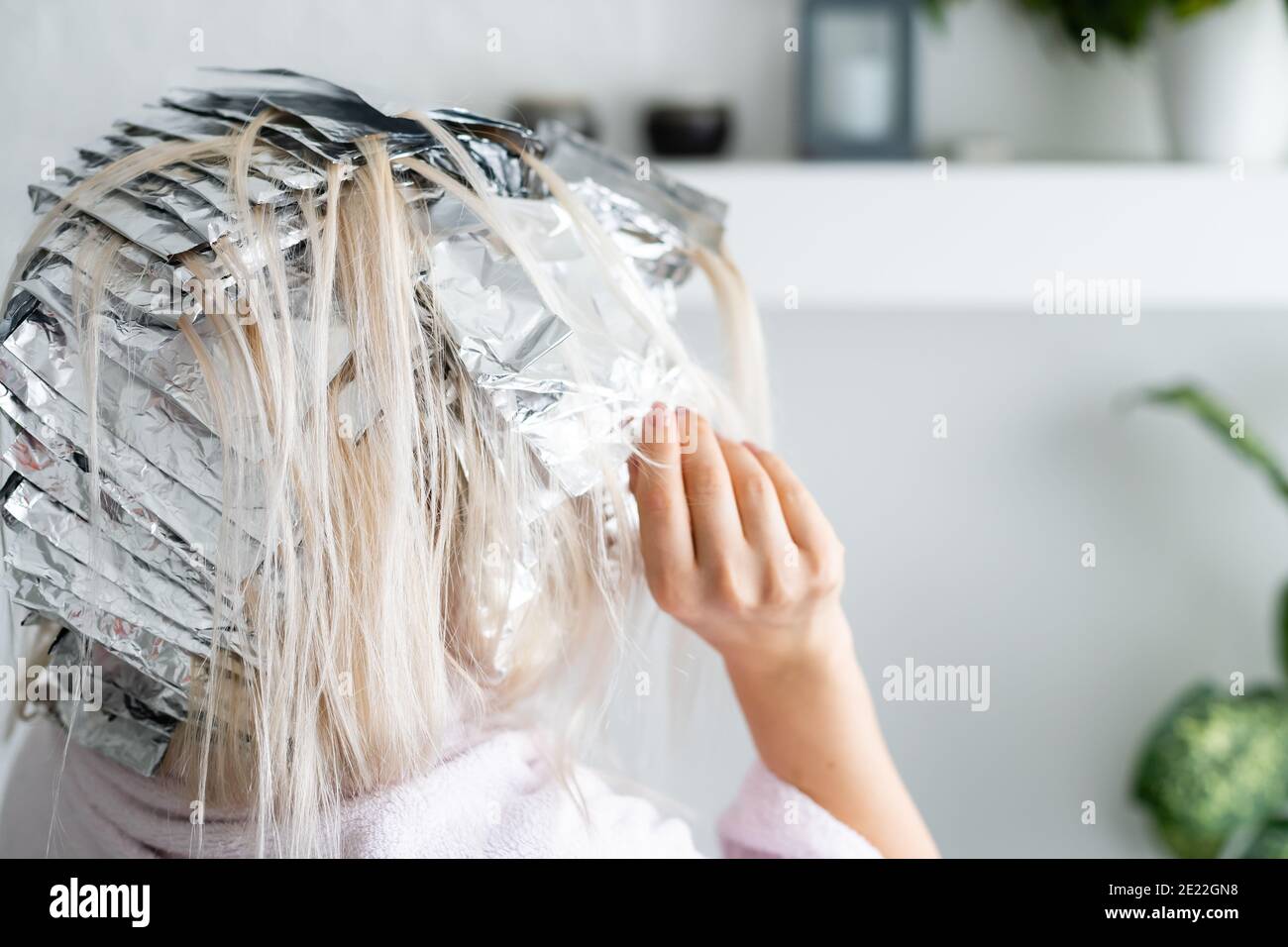 Beautiful young woman with foil on her hair. Bleaching or dyeing