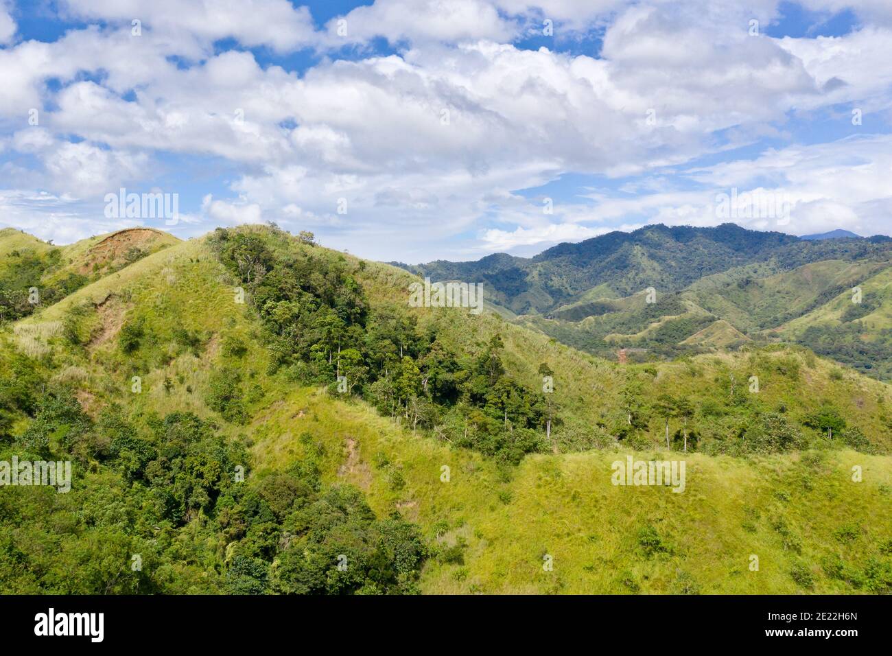 Mountain landscape with green hills and mountains with forest.Mountain valley and blue sky with clouds. Philippines, Luzon. Summer landscape. Stock Photo
