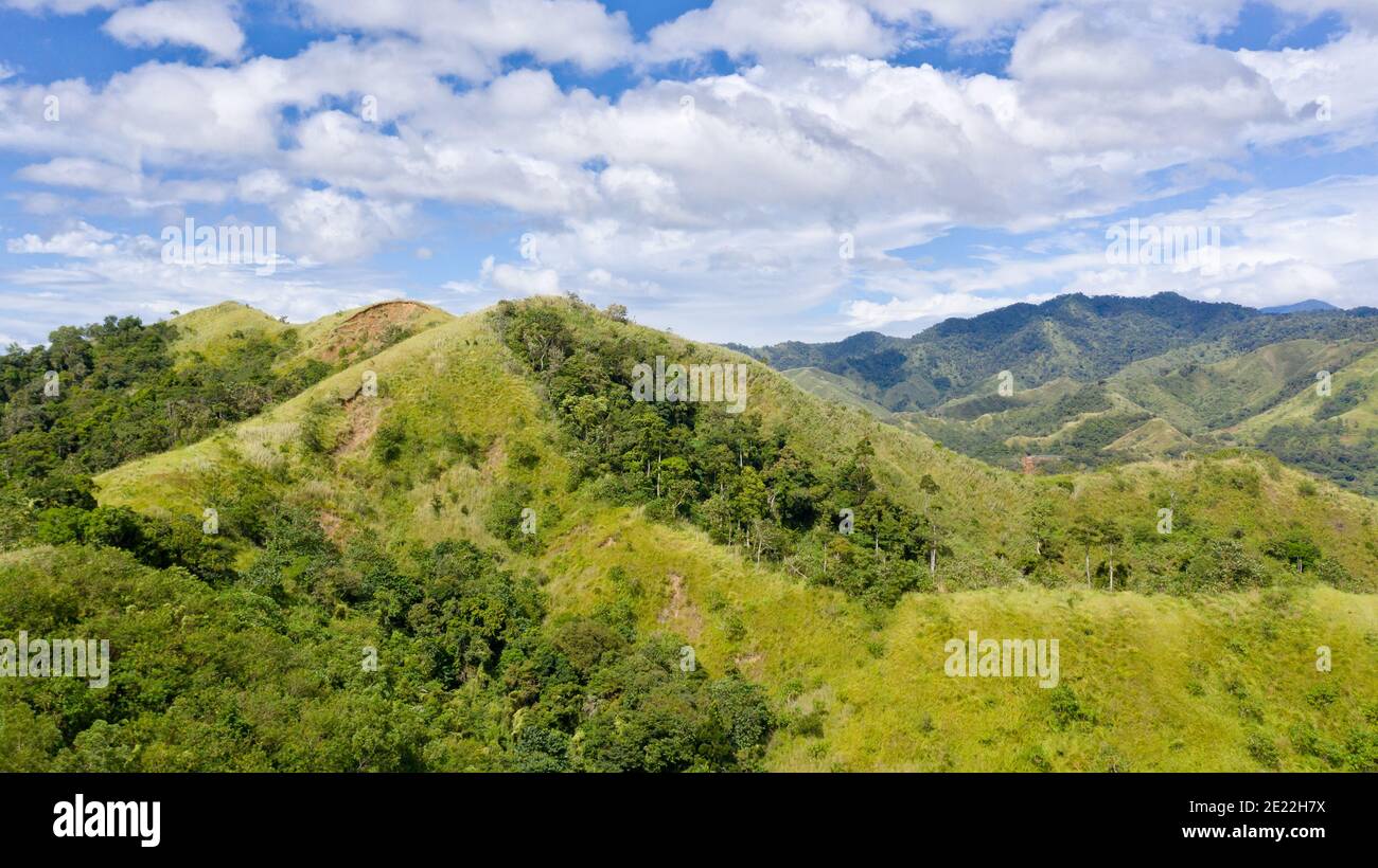 Mountain landscape with green hills and mountains with forest.Mountain valley and blue sky with clouds. Philippines, Luzon. Summer landscape. Stock Photo