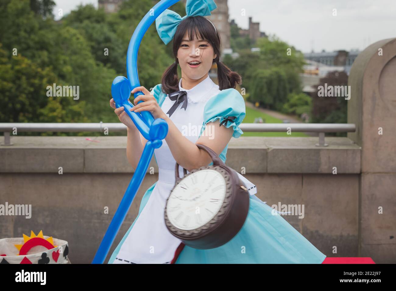 Edinburgh, Scotland - August 6 2016: A female Asian street performer does some balloon shaping to music at the Edinburgh Fringe Festival. Stock Photo