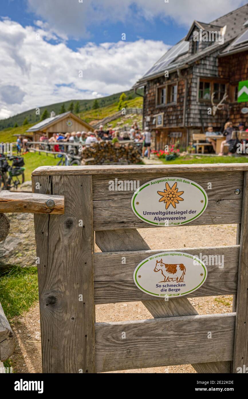 Wooden gate and tourists at the mountain hut Millstätter Hütte / Millstaetter Hütte in summer, Carinthia / Kärnten, Austria Stock Photo