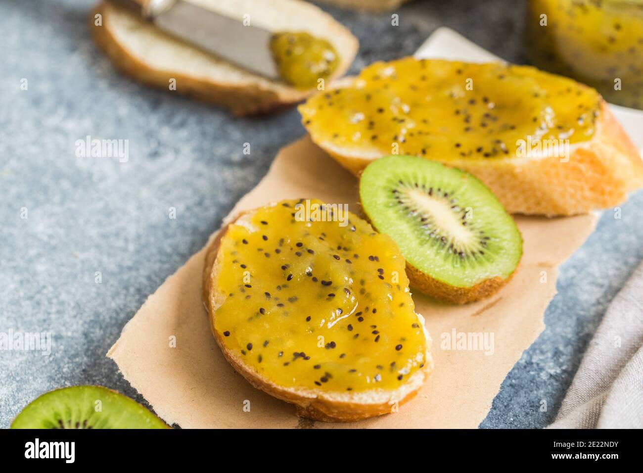 jam or marmalade made from kiwi on fresh bread. breakfast, toast with jam on a gray background Stock Photo