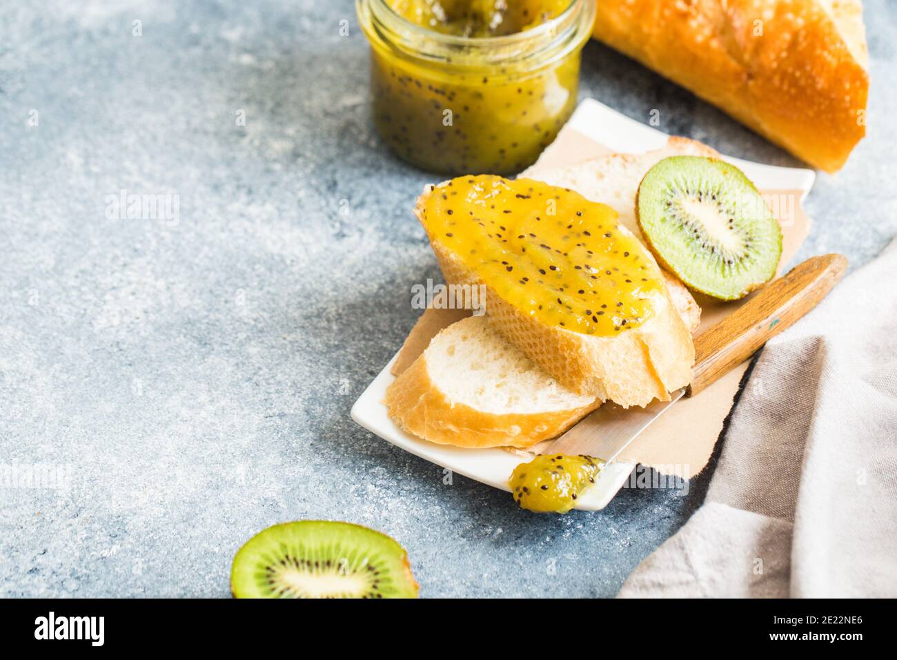 jam or marmalade made from kiwi on fresh bread. breakfast, toast with jam on a gray background Stock Photo