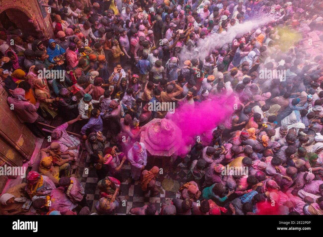 Overhead view of devotees celebrating Holi at the Banke Bihari temple. At this celebration the  participants throw colored powder at each other. Stock Photo