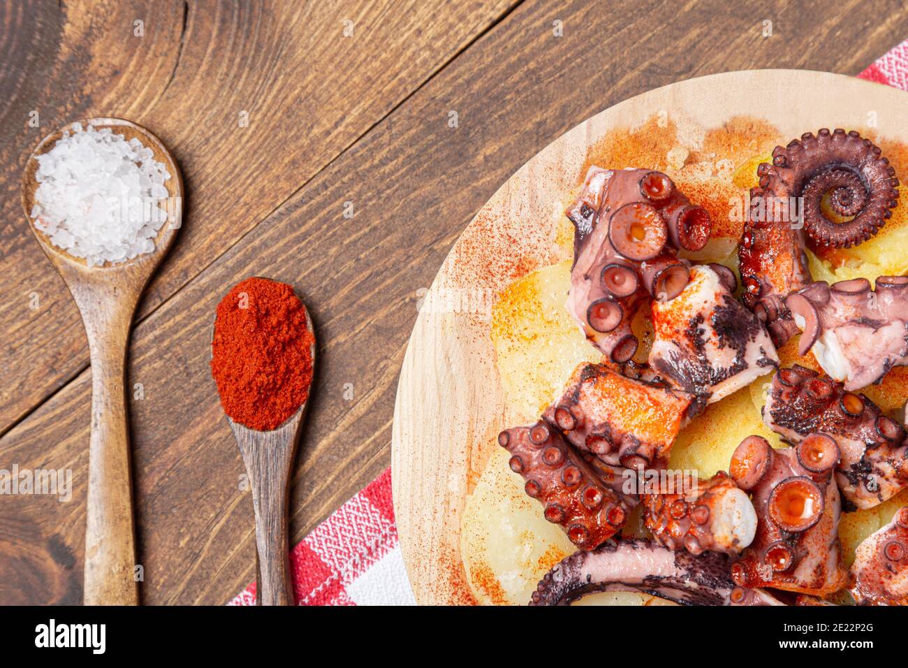 Pulpo a la gallega,galician octopus with ,potatoes paprika, salt and olive oil.  typical Spanish Galician tapa, on a traditional wooden plate. Tipical Stock Photo