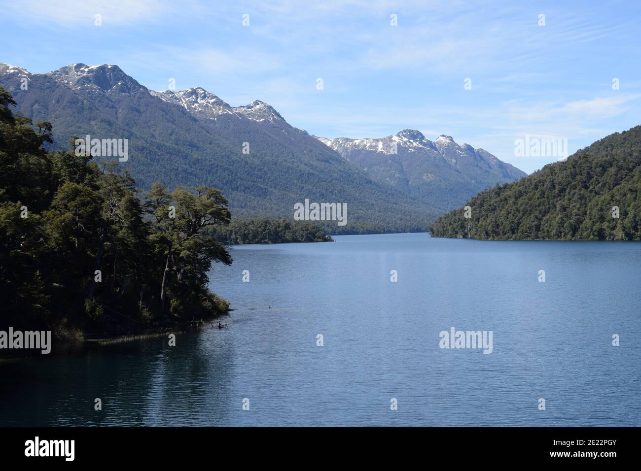 Landscape of a river surrounded by rocky hills covered in trees under a ...