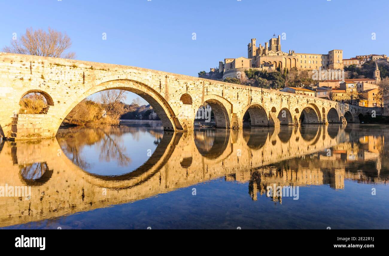 The Pont Vieux and Béziers Cathedral, and their symmetrical reflection on the Orb river, in Herault, Occitanie, France. Stock Photo