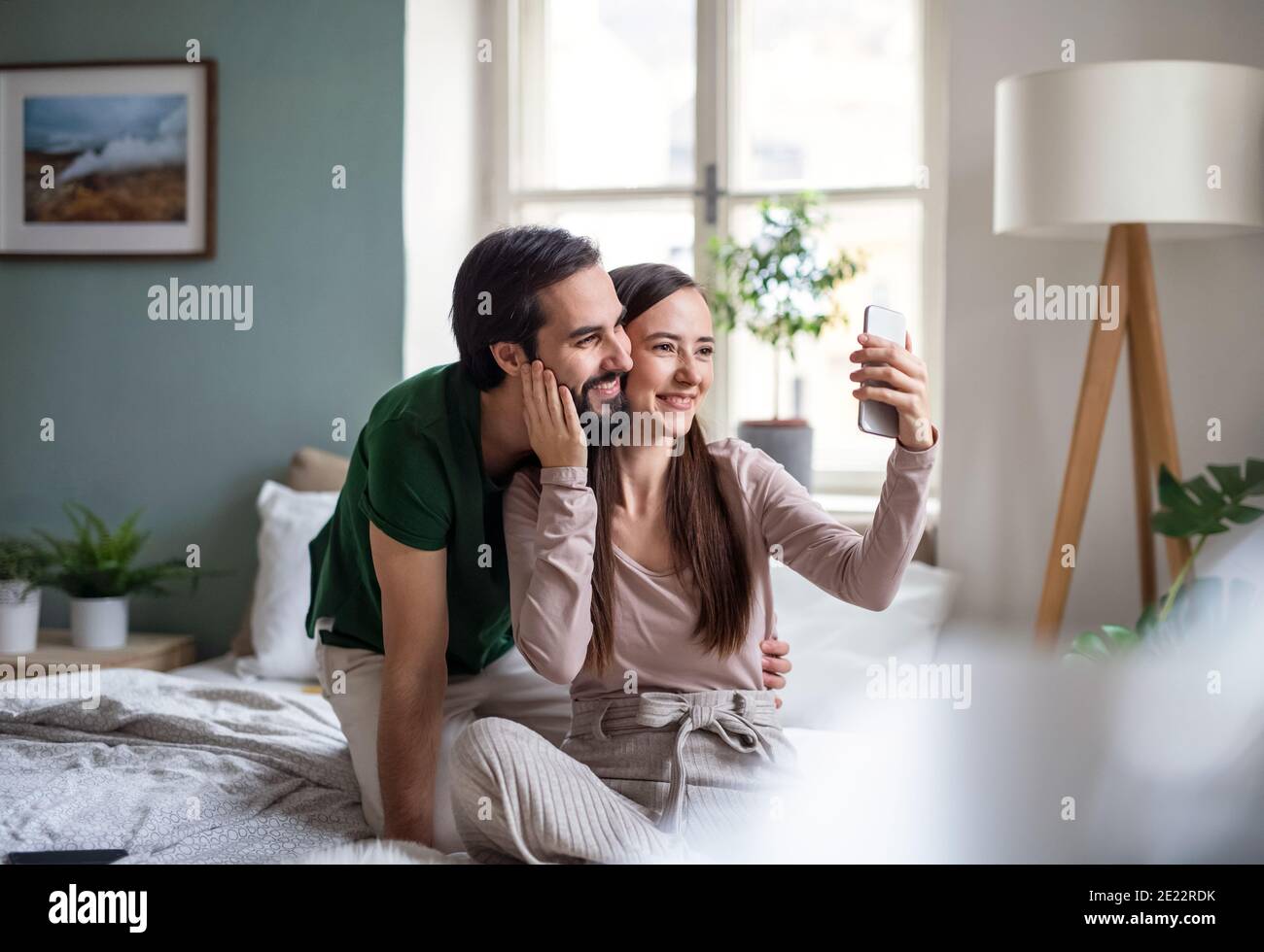 Young couple in love taking selfie on bed indoors at home Stock Photo ...