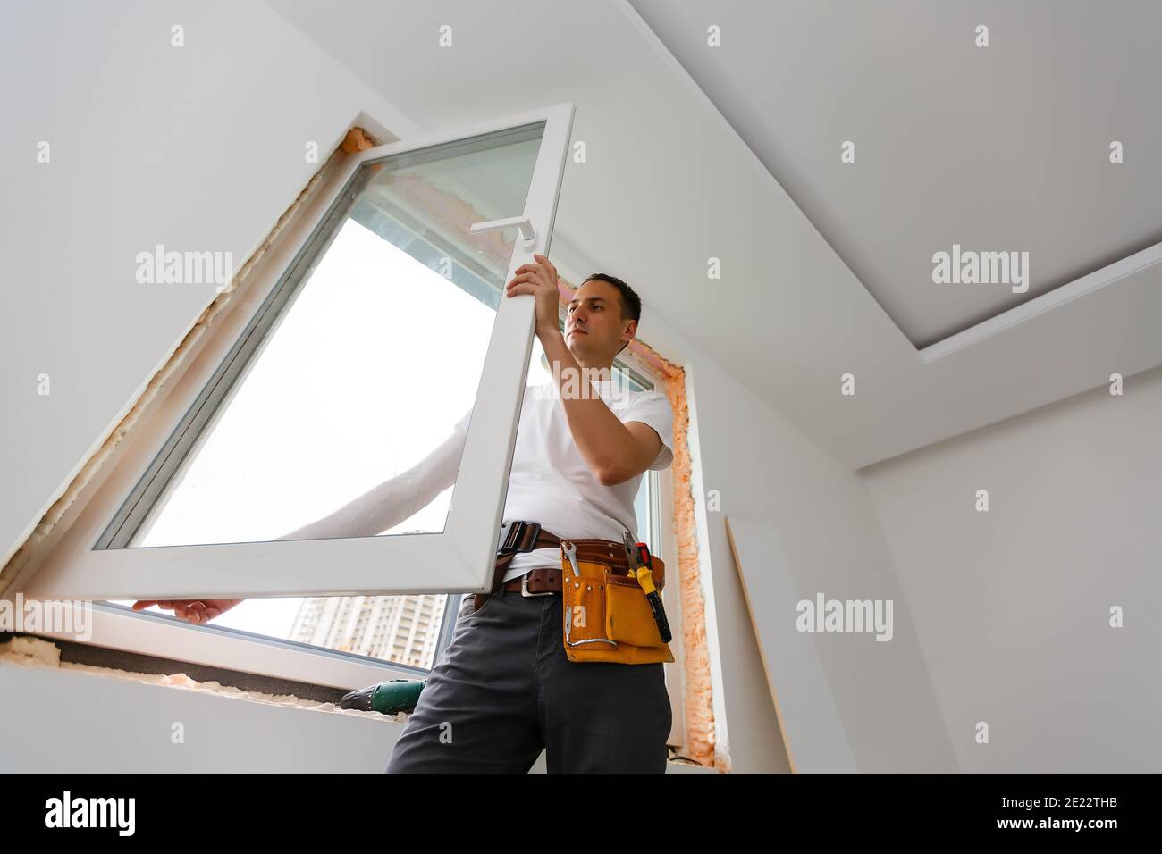 Young handyman repair window with screwdriver Stock Photo